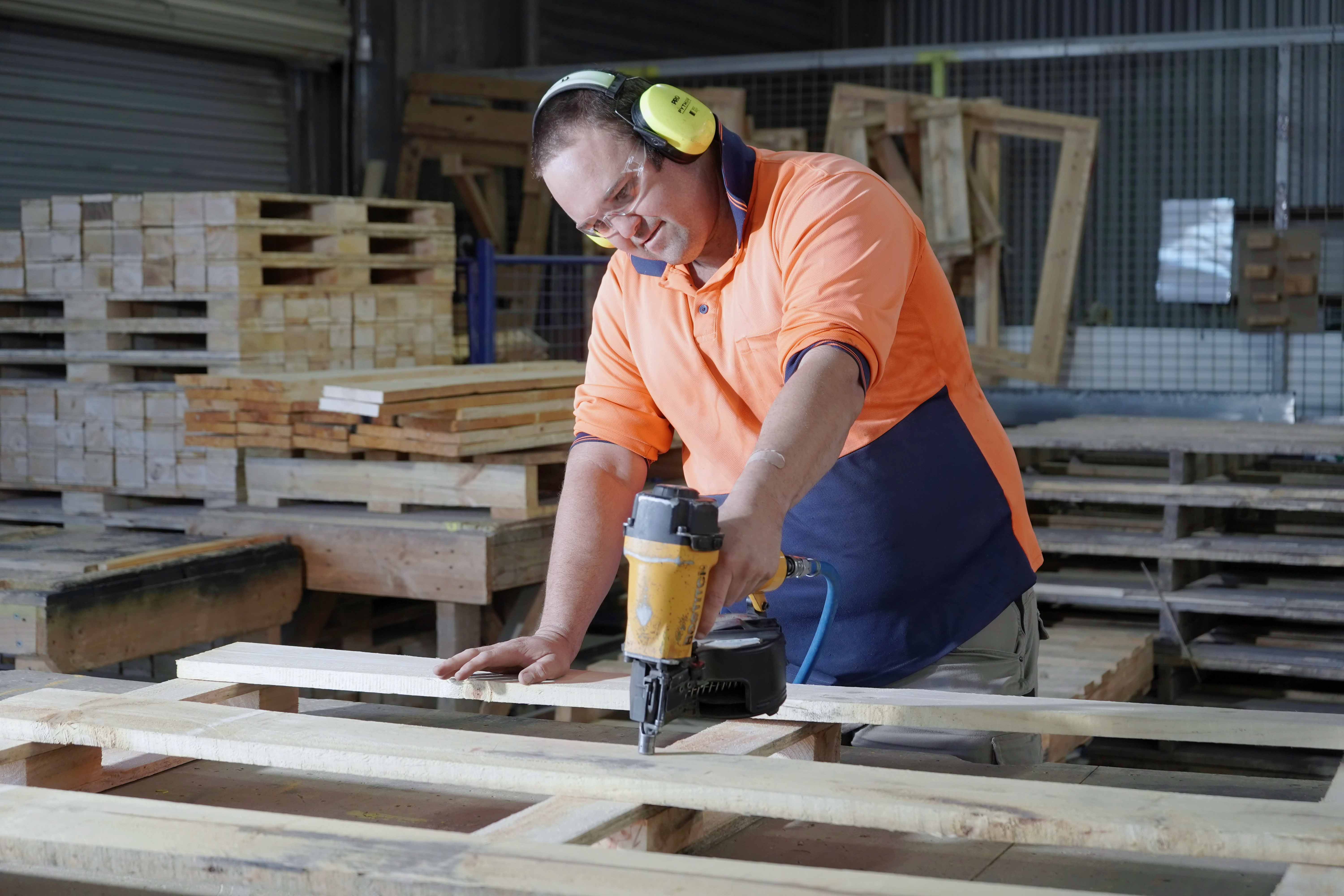 Person with a disability making pallets for sale 