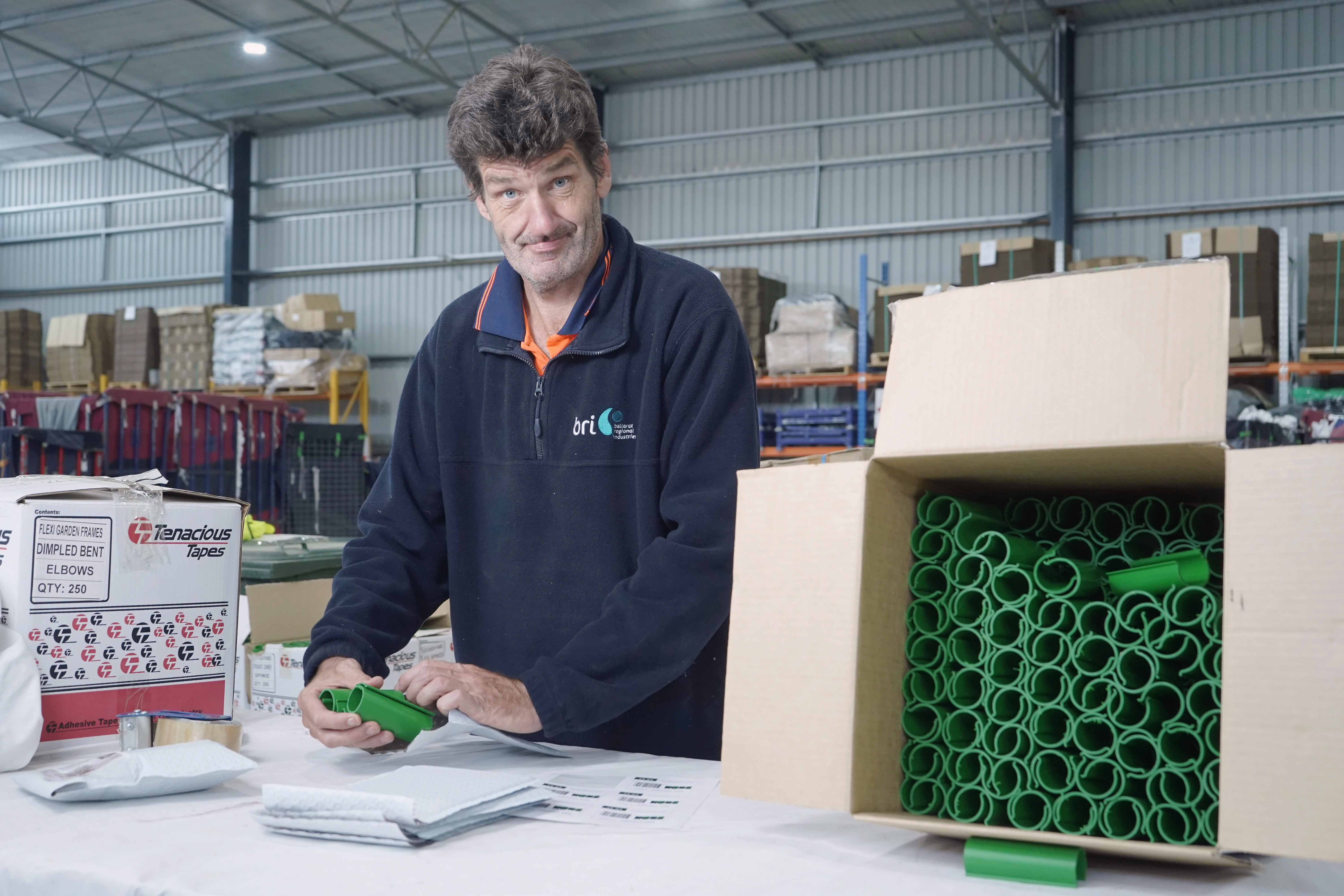 Person packing items in a box as part of a supported work program