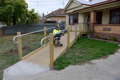 Person building a ramp at the front of a house 