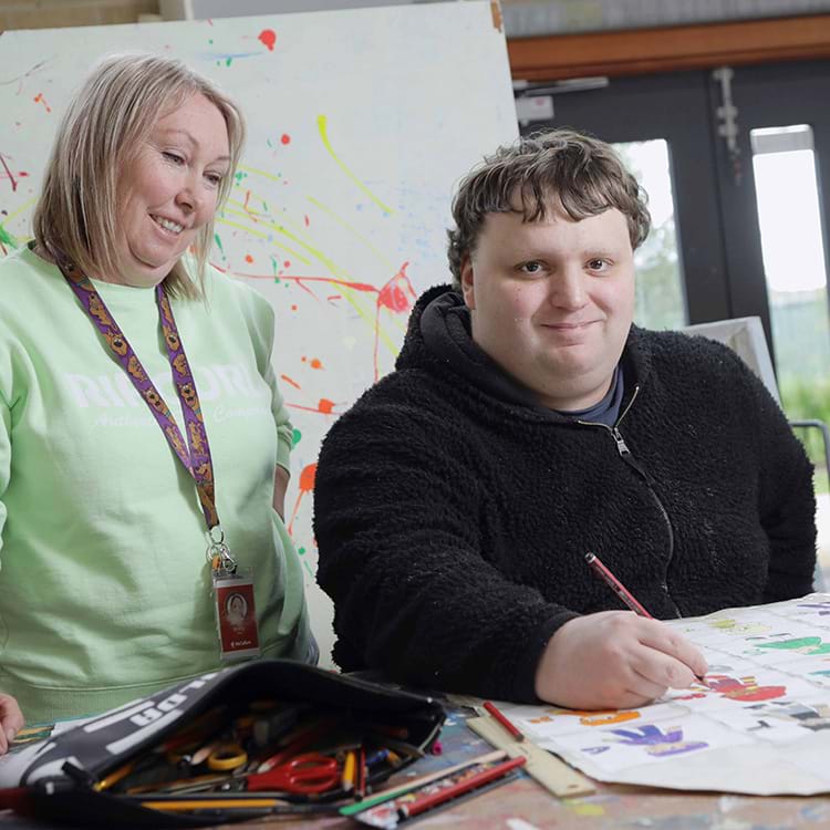 Person being supported to complete activities in the art room