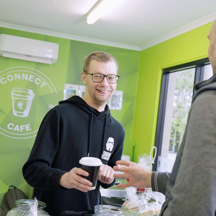 Person serving coffee to a customer in the Connect Cafe